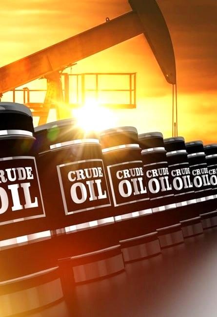 Crude oil barrels with a pumpjack at sunset